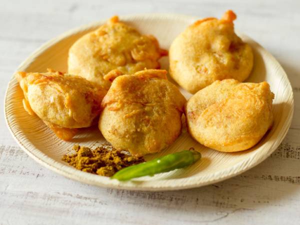 Batata Vada—Fitter prepared by deep-frying mashed potato patty in chickpea flour batter. A popular way to eat it is in the form of Vada Pav. Pav, which means bread, also derives from the Portuguese word pão.